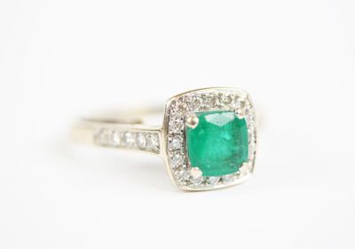 an emerald and diamond ring on a white background
