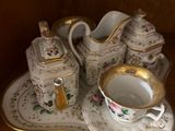 a picture of a tea set on a shelf in a cabinet