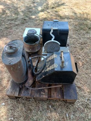 un tas de vieux objets posés sur une palette dans l'herbe