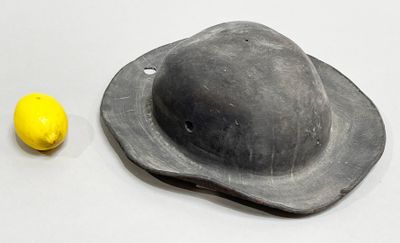 a black hat and a lemon on a table