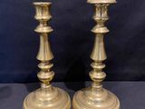 pair of antique brass candlesticks on a black background