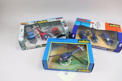 trois jouets emballés, dont un hélicoptère et un camion de pompiers