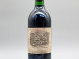 une vieille bouteille de vin posée sur une table blanche