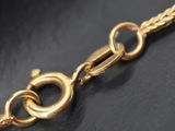 a close up of a gold chain on a black surface