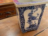 a blue and white flower pot on a wooden table