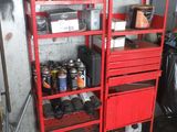 une étagère rouge dans un garage, sur laquelle sont posés des outils