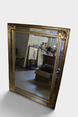 a mirror that is sitting on the floor in front of a chair