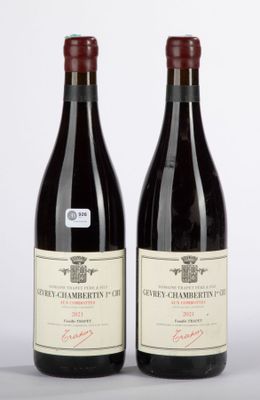 two bottles of red wine sitting next to each other on a table