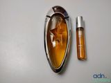 an image of a bottle of perfume next to a bottle of perfume