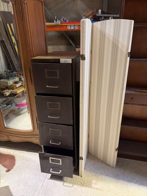 a tall cabinet with drawers and a mirror in the corner