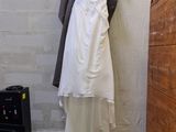 a wedding dress hanging on a clothes rack in a room