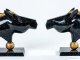 pair of black and gold horse head bookends on marble bases
