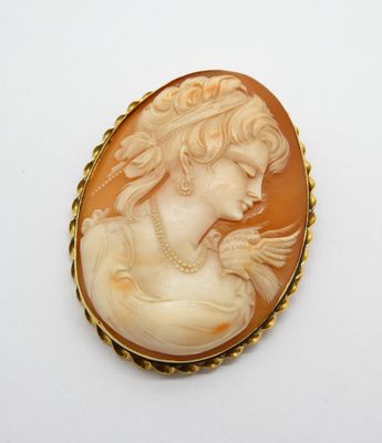 un camée ancien en coquillage représentant une femme portant un collier de perles