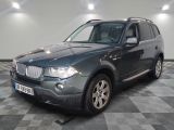 a picture of a grey bmw suv parked in a garage
