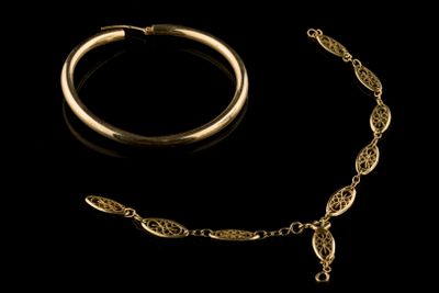 une image représentant un collier et un bracelet en or sur fond noir