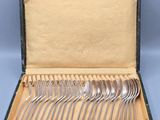 a box with a set of silverware in it on a blue surface