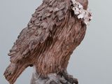 a statue of a bird sitting on top of a wooden table