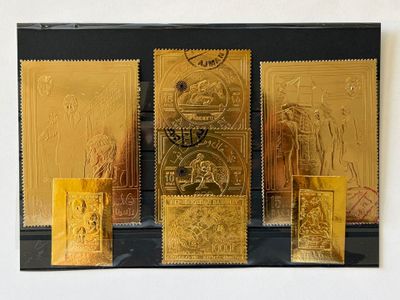trois timbres dorés exposés sur un fond noir