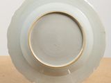 a white plate with a gold rim sitting on a table