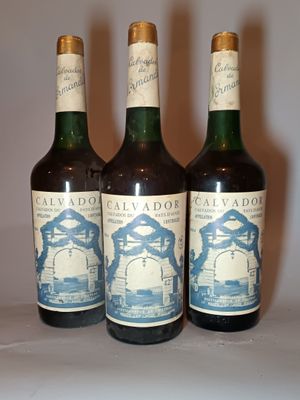 trois bouteilles de vin posées sur une table l'une à côté de l'autre