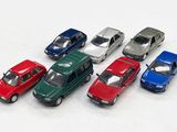 plusieurs petites voitures sont alignées sur une surface blanche
