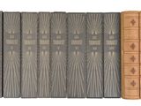 trois livres sont alignés sur une surface blanche