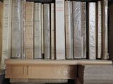 many books that are stacked on a shelf in a room