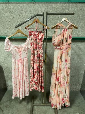 three dresses hanging on a clothes rack in a room