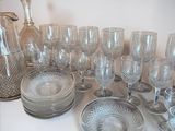 a lot of glassware on a table with a pitcher