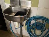 a sink with a hose next to it in a bathroom
