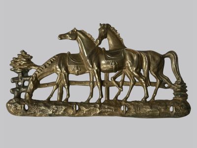 une sculpture en bronze représentant trois chevaux et un homme à cheval
