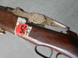 a close up of a rifle with a red sticker on it