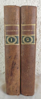 two old books sitting on top of a table next to each other