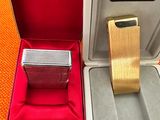 une montre en argent dans un coffret rouge, avec un bracelet en or