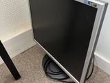 a flat screen tv sitting on the floor next to a chair