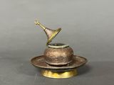 an antique brass teapot with a saucer and saucer on a saucer