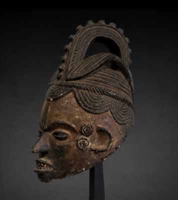 un masque en bois sur fond noir et un fond noir