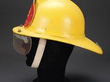 a yellow fireman ' s helmet on a mannequin head