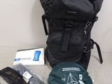 un sac à dos et d'autres objets posés par terre près du mur
