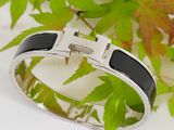 silver and black enamel bracelet with a cross on it
