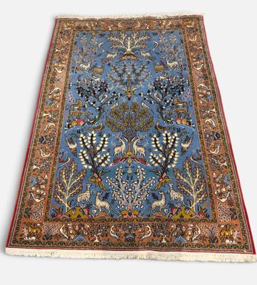 un tapis bleu orné d'oiseaux et de fleurs