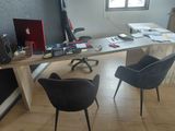 a desk with two chairs and a laptop on it