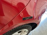 a close up of a red car with a sticker on it