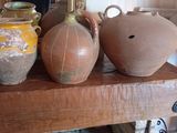 un homme en train de prendre une photo de trois vases posés sur une étagère