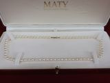 a white box with pearls in it on a red surface