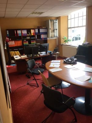 une photo d'un bureau avec un bureau et des chaises
