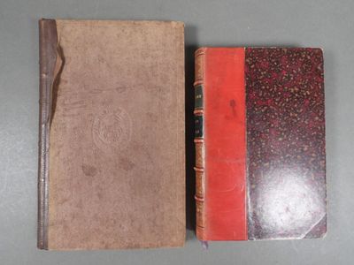 two old books sitting on top of a table next to each other