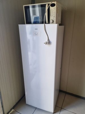un petit réfrigérateur blanc surmonté d'un micro-ondes