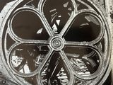 a black and white photo of an old machine wheel
