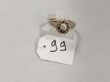 gros plan d'une bague sur une surface blanche avec une étiquette de prix